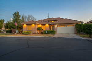 View of front facade featuring a garage, driveway, a tiled roof, and stucco siding