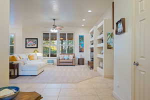 Living room featuring light tile patterned floors, baseboards, built in features, light colored carpet, and recessed lighting