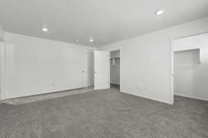 Interior space with baseboards, a textured ceiling, and recessed lighting