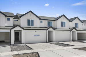 View of front of house featuring board and batten siding, concrete driveway, and an attached garage