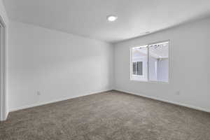 Unfurnished room featuring carpet floors, visible vents, and baseboards