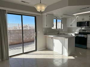 Kitchen featuring stainless steel appliances, visible vents, a peninsula, and a textured ceiling