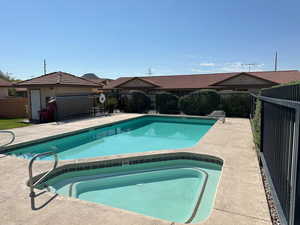 View of pool featuring a fenced in pool, a patio area, fence, and an in ground hot tub