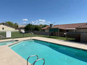 Pool featuring central AC unit, a lawn, and fence