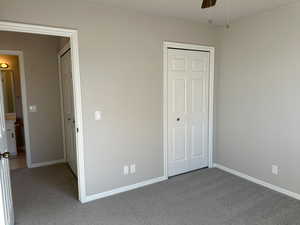 Unfurnished bedroom with a closet, carpet flooring, a ceiling fan, and baseboards