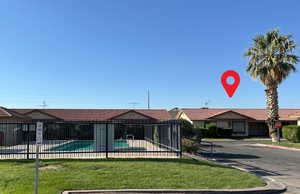 Exterior space featuring a community pool and fence