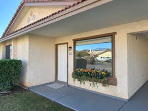 Property entrance featuring a tiled roof and stucco siding