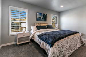 Bedroom with recessed lighting, dark carpet, and baseboards