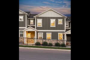 View of front facade featuring board and batten siding and fence