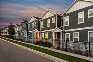 Townhome / multi-family property with board and batten siding, fence, and a residential view