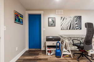 Office featuring baseboards, visible vents, and dark wood-type flooring