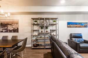 Dining area with a chandelier, wood finished floors, and baseboards