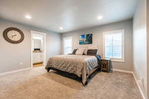 Bedroom featuring light carpet, multiple windows, recessed lighting, and baseboards