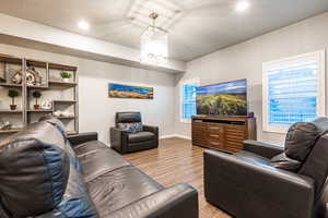 Living room featuring light wood-type flooring, baseboards, and recessed lighting