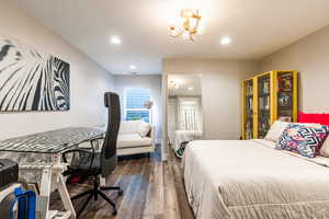 Bedroom featuring a notable chandelier, dark wood finished floors, recessed lighting, visible vents, and a textured ceiling