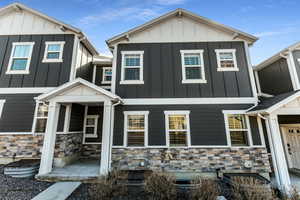 View of front facade featuring stone siding and board and batten siding