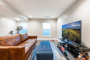 Living room with recessed lighting, wood finished floors, visible vents, and baseboards