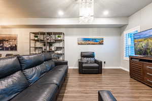 Living area featuring baseboards, wood finished floors, and recessed lighting