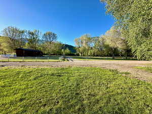 View of yard with a rural view and fence