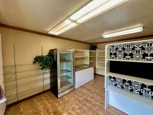 Interior space with crown molding, a textured ceiling, and wood finished floors