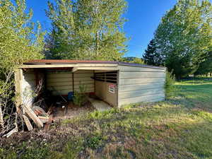 View of pole building with a carport and a yard