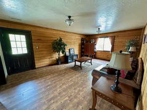 Living room with visible vents, a textured ceiling, and wood finished floors