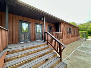 Property entrance with a porch and board and batten siding