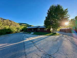 Ranch-style house with a mountain view, aphalt driveway, and a front yard