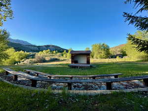 Exterior space with an outbuilding, a mountain view, a storage shed, and a lawn