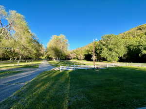 View of community with a rural view, fence, and a yard