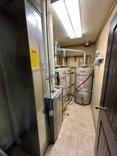 Utility room featuring gas water heater, water heater, and heating unit