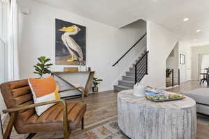 Living area with visible vents, baseboards, wood finished floors, stairs, and recessed lighting