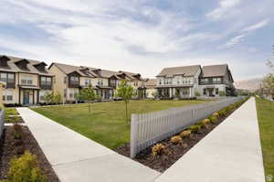 View of community featuring a yard, a residential view, and fence