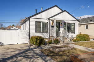 View of front of house featuring driveway, a vegetable garden, a gate, and fence