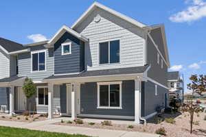 View of front of house featuring a shingled roof, a porch, and central AC