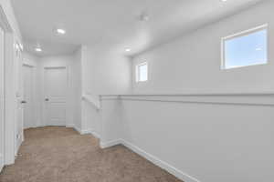 Interior space featuring carpet floors, recessed lighting, an upstairs landing, and baseboards