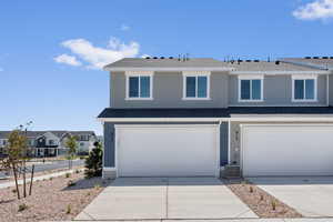 View of front of home featuring a shingled roof, a residential view, driveway, and an attached garage