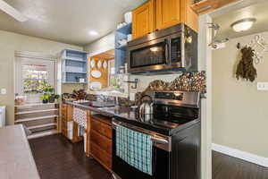 Kitchen with custom river rock backsplash and induction stove