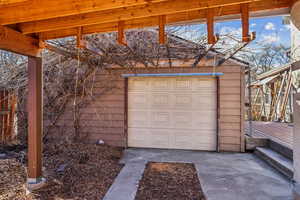 Oversized, one car garage with lots of room for storage, and a pergola covered in vines that are beautiful in the spring and summer