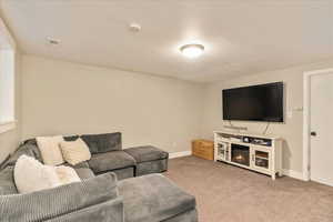 Living area featuring carpet flooring, visible vents, and baseboards