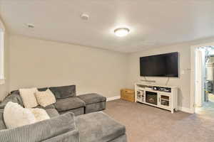 Living area with carpet flooring, visible vents, and baseboards