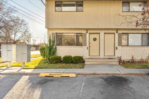 Property entrance featuring uncovered parking and brick siding