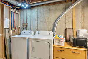 Washroom with laundry area and washing machine and clothes dryer