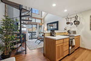 Kitchen with stainless steel range oven, plenty of natural light, light countertops, and a peninsula