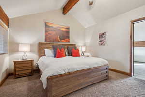 Bedroom with carpet flooring, ceiling fan, lofted ceiling with beams, and baseboards