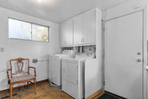 Clothes washing area featuring cabinet space, baseboards, visible vents, and separate washer and dryer