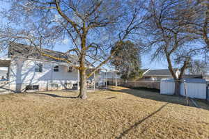 View of yard with an outbuilding, a shed, and fence