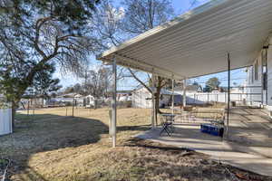 View of yard with an outbuilding, fence, and a patio