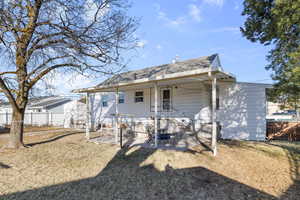 Rear view of house with a yard, a patio area, fence, and roof with shingles