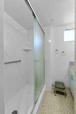 Bathroom featuring a marble finish shower